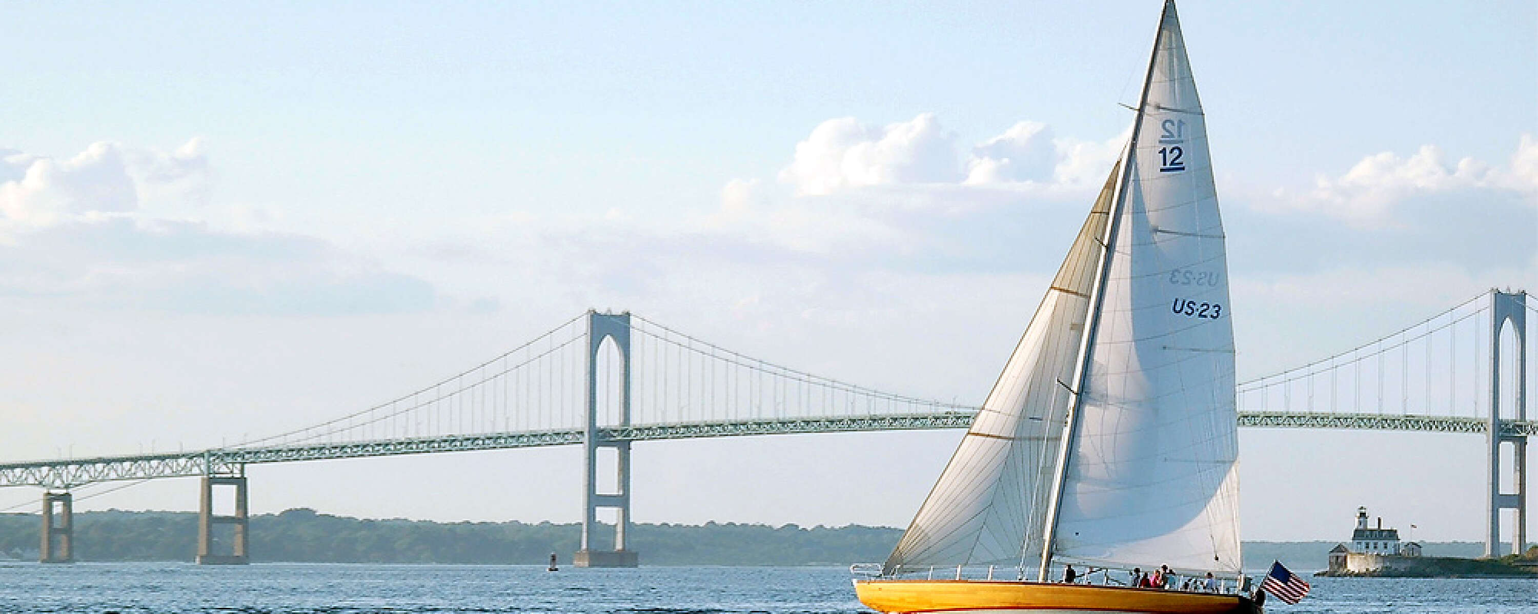 Sailboat sailing in front of a bridge in Newport